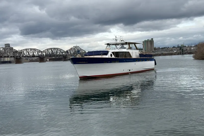 Slide: The Image of 1961 Chris-Craft 55 yacht on a river with a bridge in the background. - 6