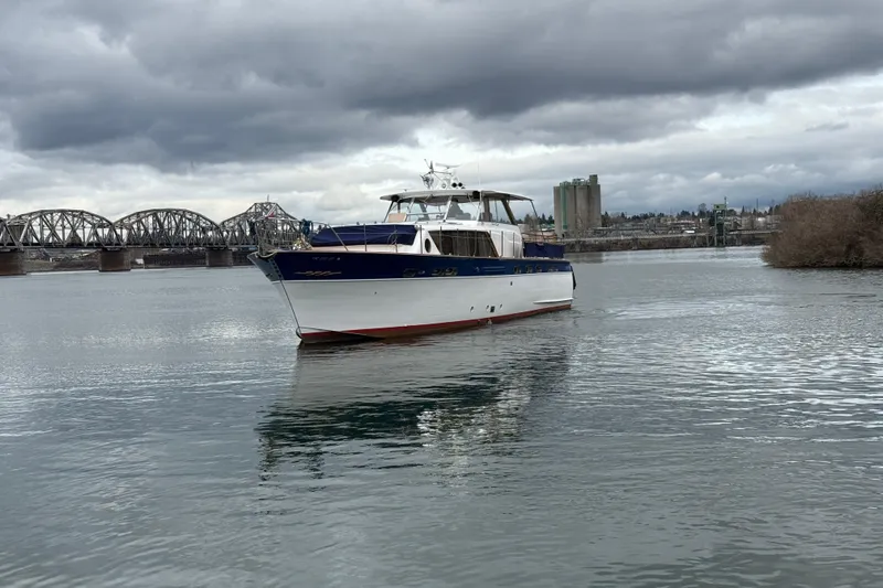 Slide: The Image of 1961 Chris-Craft 55 yacht on a river with a bridge in the background. - 7