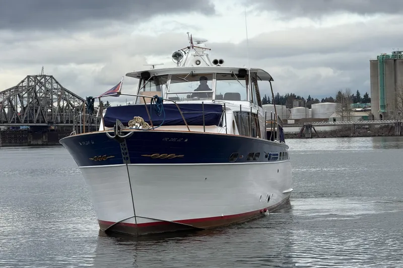 Slide: The Image of 1961 Chris-Craft 55 yacht on water, with industrial backdrop and cloudy sky. - 8