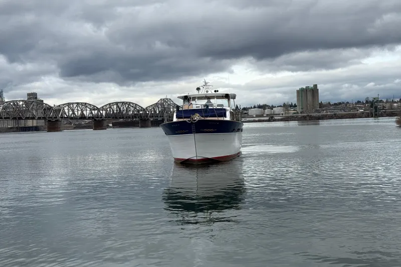 Slide: The Image of 1961 Chris-Craft 55 yacht on a river with a bridge and industrial background. - 9