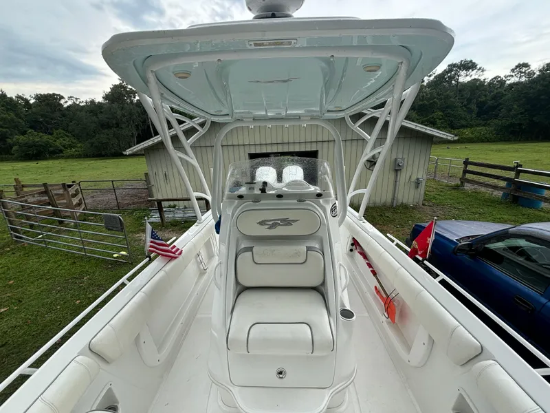 Slide: The Image of 2021 Glasstream 280 SCX boat interior with seating and canopy, parked near a barn. - 10