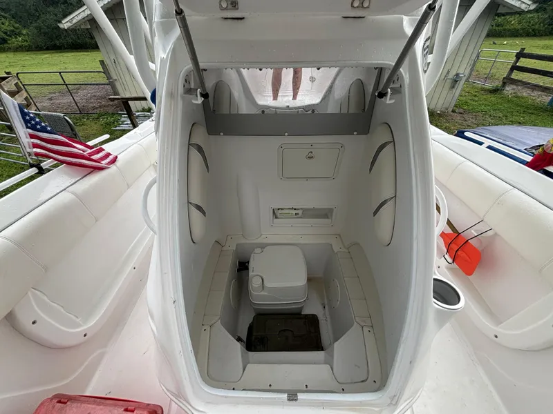 Slide: The Image of 2021 Glasstream 280 SCX boat interior with open hatch and portable toilet. - 12