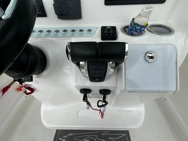 Slide: The Image of 2021 Glasstream 280 SCX boat controls with cup holder and switches. - 18