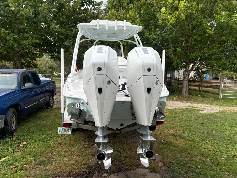 Slide: The Image of 2021 Glasstream 280 SCX boat with dual outboard motors, parked on grass. - 5