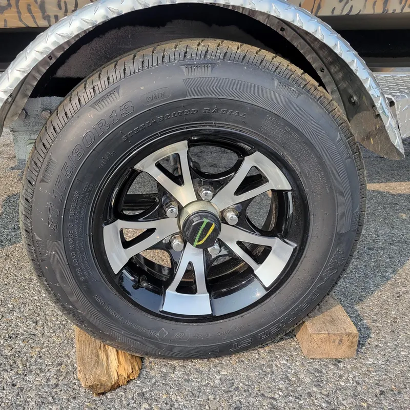 Slide: The Image of 2025 Xpress H18DB Duck boat trailer tire on wooden block, close-up view. - 7