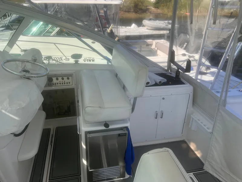 Slide: The Image of Interior of a 2003 Cabo Express boat with white seating and control panel. - 10