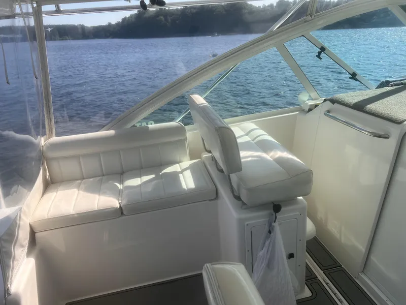 Slide: The Image of 2003 Cabo Express boat interior with white seating, overlooking serene water and distant shoreline. - 11