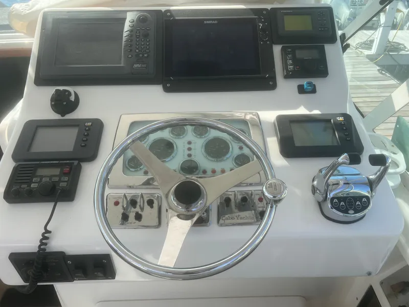 Slide: The Image of Helm of 2003 Cabo 35 Express boat with steering wheel and navigation equipment. - 13