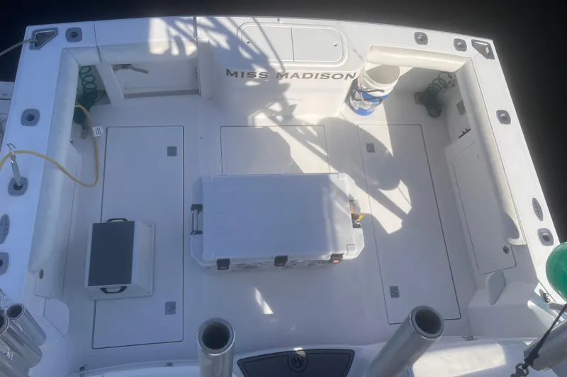 Slide: The Image of 2003 Cabo Express boat deck with storage compartments and fishing gear. - 7