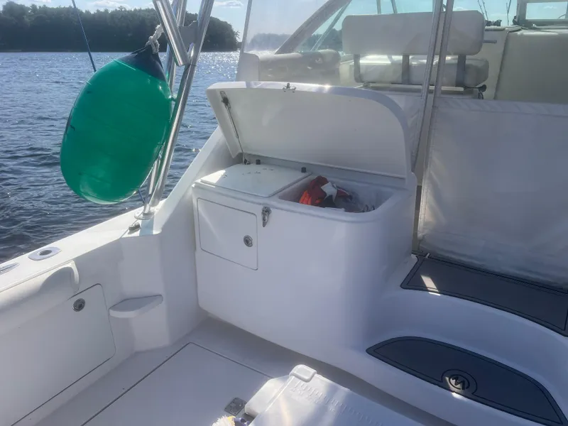 Slide: The Image of 2003 Cabo Express boat interior with open storage compartment, docked on a sunny day. - 8