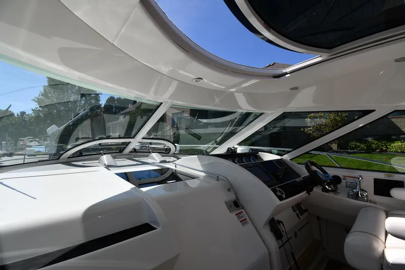 Slide: The Image of Interior view of 2010 Sea Ray 450 Sundancer yacht cockpit with modern controls and seating. - 12