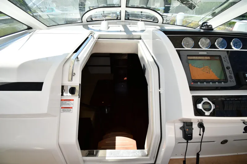 Slide: The Image of 2010 Sea Ray 450 Sundancer helm with navigation system and cabin entrance. - 32