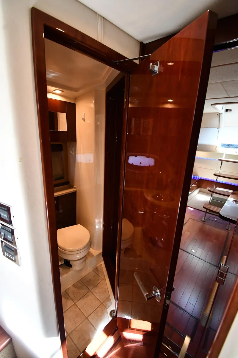 Slide: The Image of 2010 Sea Ray 450 Sundancer yacht bathroom with wooden door and modern fixtures. - 42