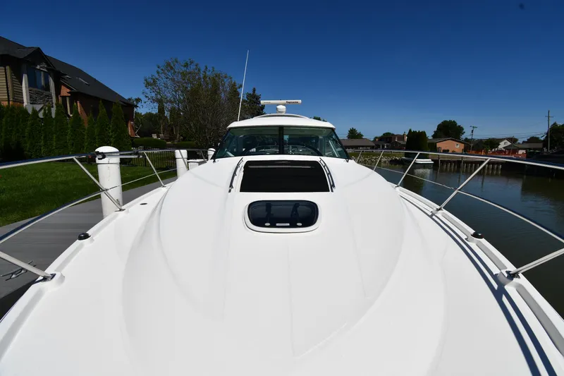Slide: The Image of 2010 Sea Ray 450 Sundancer yacht docked, showcasing sleek design and spacious deck. - 7