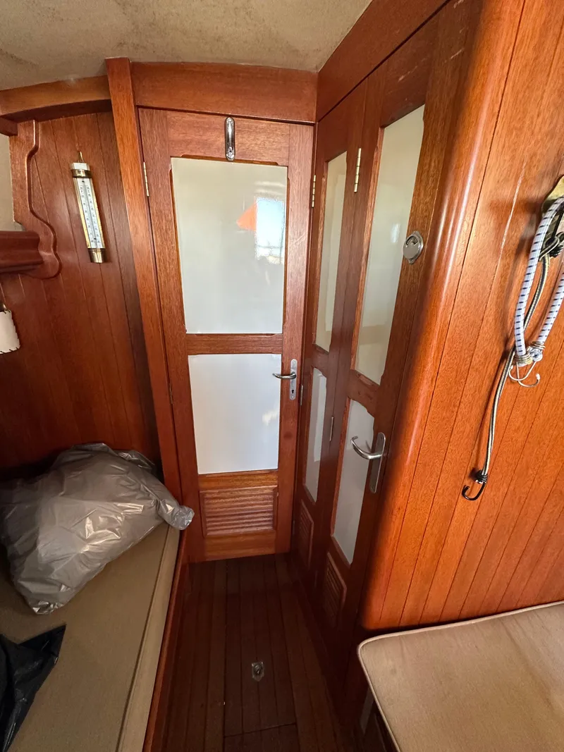 Slide: The Image of Interior of 1972 Mariner 31 Ketch with wooden doors and cozy cabin space. - 10