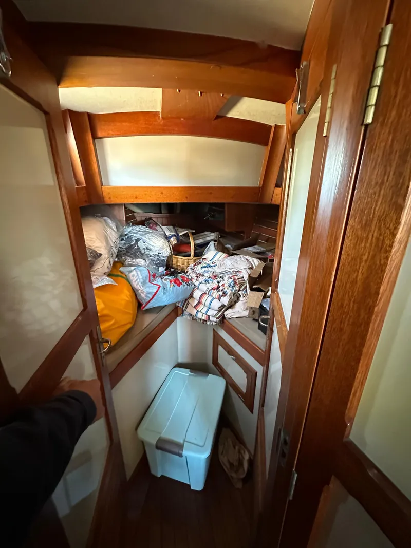 Slide: The Image of Interior of a 1972 Mariner 31 Ketch with wooden paneling and storage area. - 17