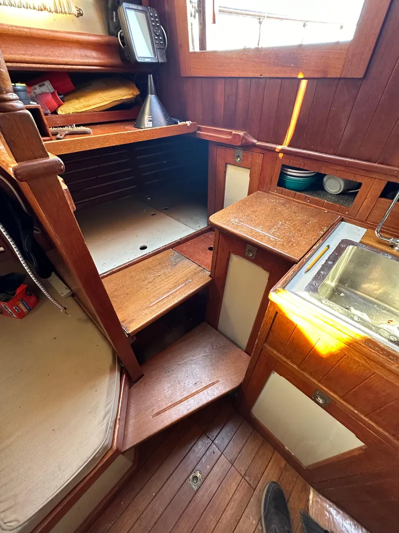 Slide: The Image of Interior of a 1972 Mariner 31 Ketch sailboat with wooden cabinetry and compact kitchen area. - 20