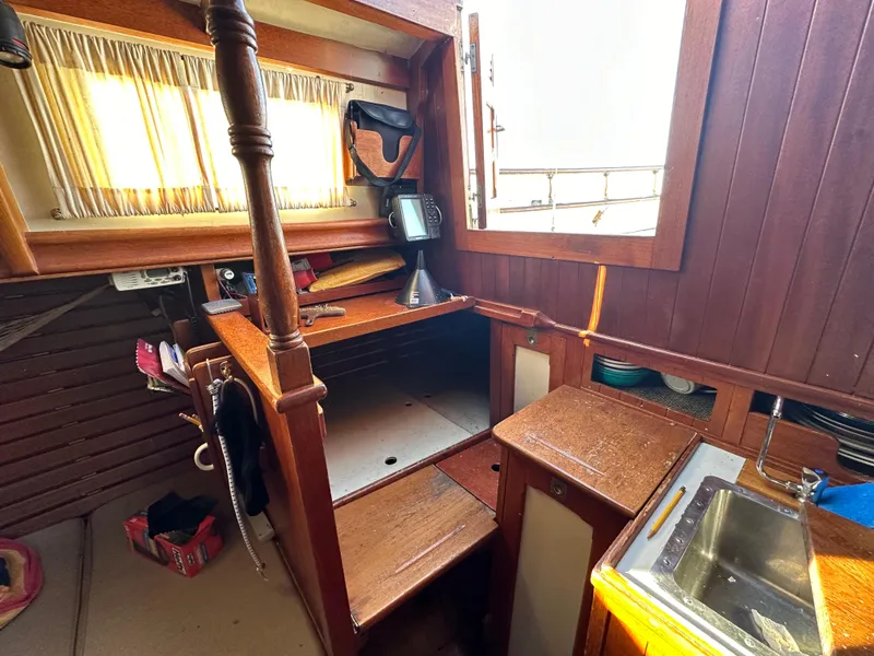 Slide: The Image of Interior of 1972 Mariner 31 Ketch with wooden cabinetry and small sink. - 21