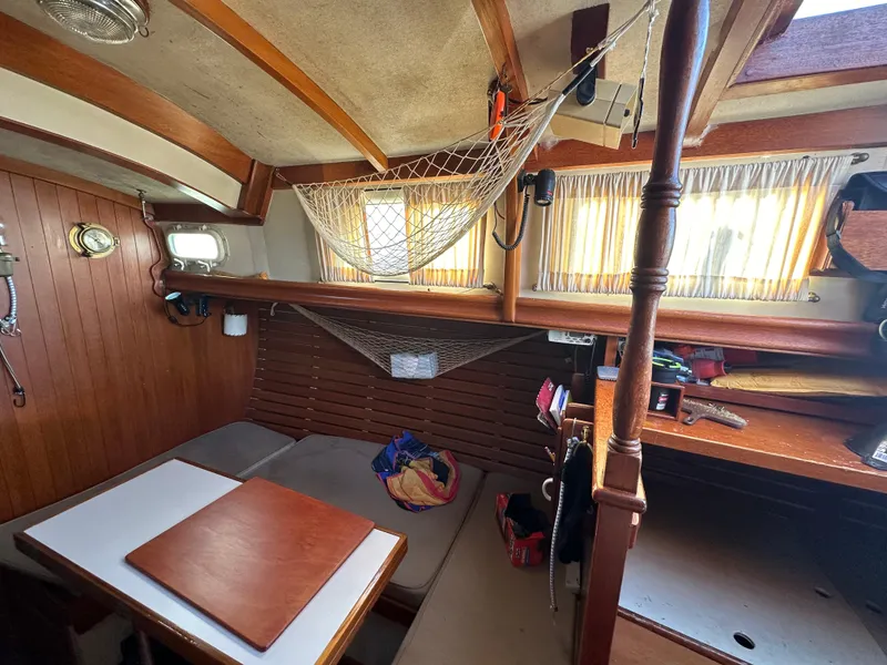 Slide: The Image of Interior of a 1972 Mariner 31 Ketch sailboat with wooden accents and cozy seating. - 22