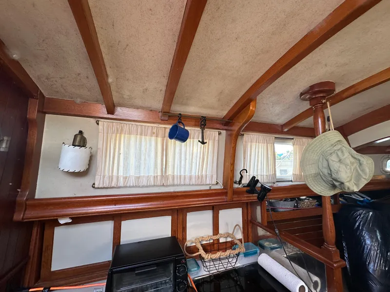 Slide: The Image of Interior of a 1972 Mariner 31 Ketch with wooden beams and nautical decor. - 23