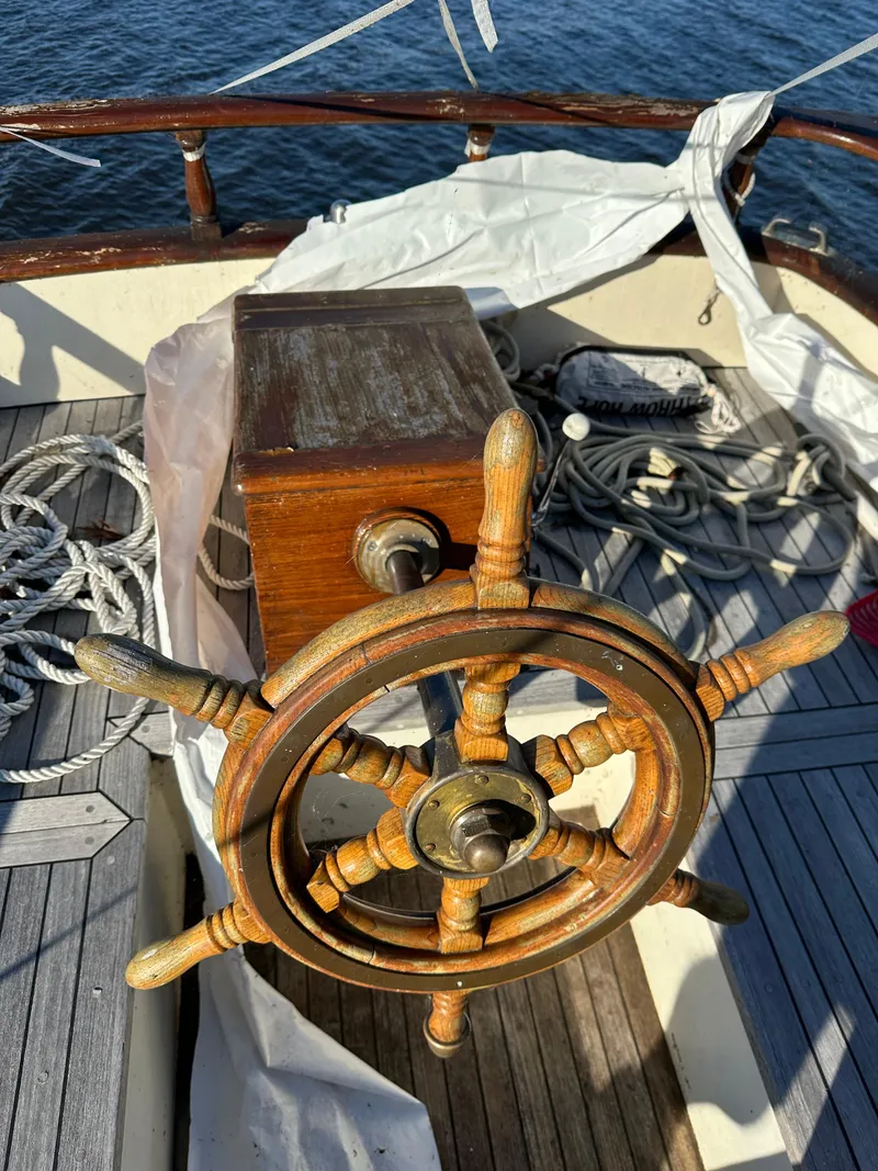 Slide: The Image of Wooden helm of a 1972 Mariner 31 Ketch sailboat with ropes on deck. - 25