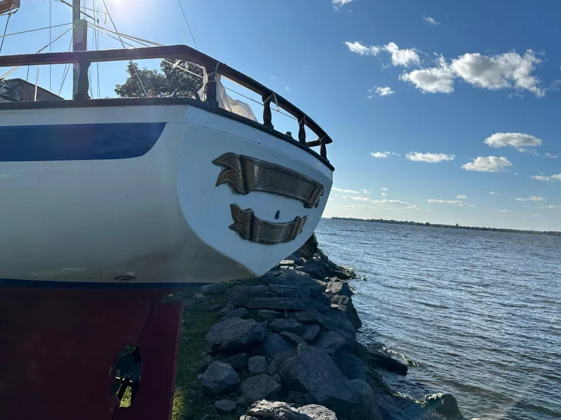 Slide: The Image of 1972 Mariner 31 Ketch sailboat by the water on a sunny day. - 3