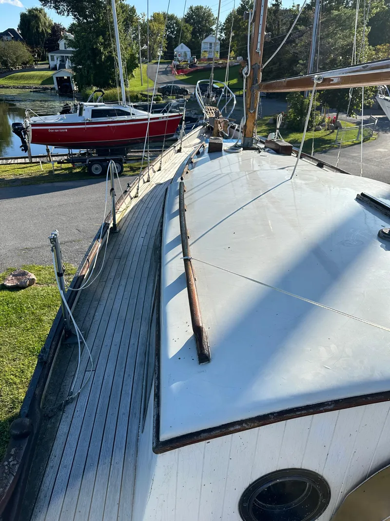 Slide: The Image of 1972 Mariner 31 Ketch sailboat on land, with a scenic background. - 5