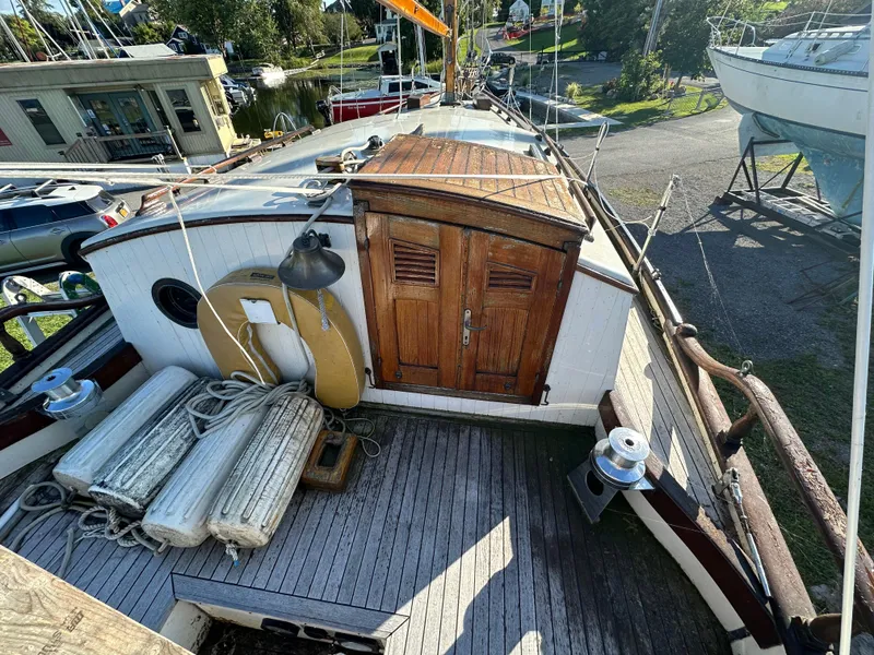 Slide: The Image of 1972 Mariner 31 Ketch deck with wooden hatch, life preserver, and ropes. - 8