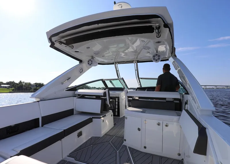 Slide: The Image of 2023 Monterey 385 Super Sport boat interior with seating and helm, on a sunny day. - 11