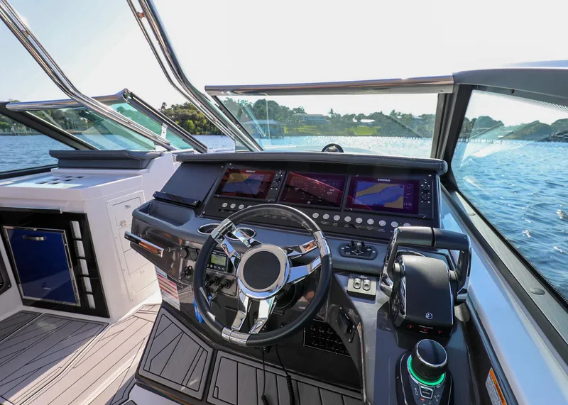 Slide: The Image of 2023 Monterey 385 Super Sport boat helm with modern controls and scenic water view. - 24