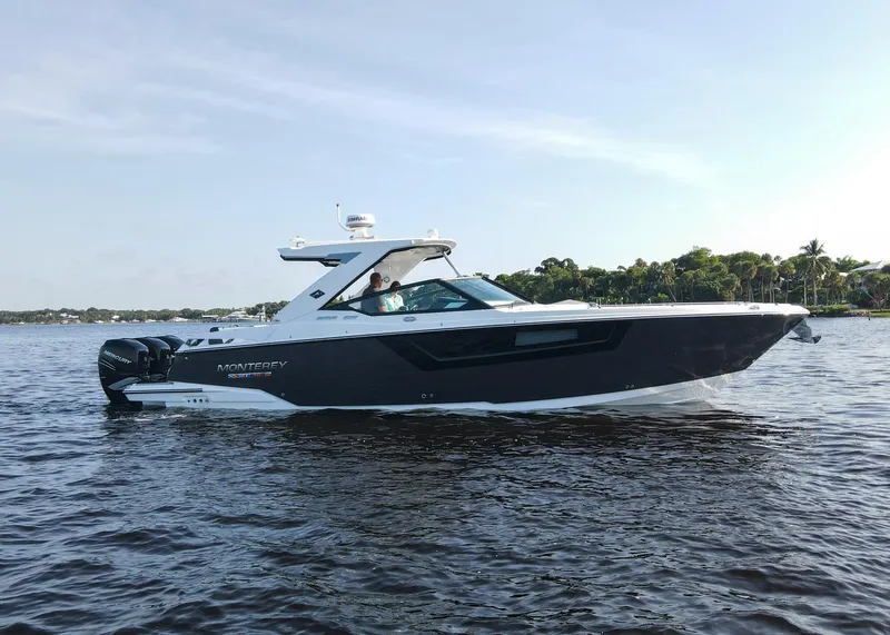 Slide: The Image of 2023 Monterey 385 Super Sport boat cruising on a calm lake. - 7