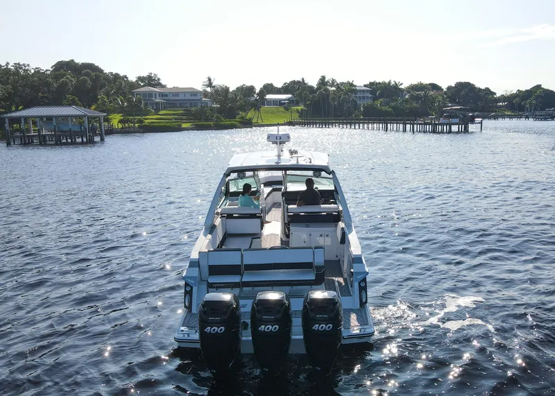 Slide: The Image of 2023 Monterey 385 Super Sport boat cruising on a sunny lake. - 9