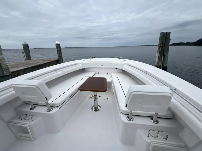 Slide: The Image of 2019 Southport 33 FE boat interior with seating and table, docked by calm waters. - 5