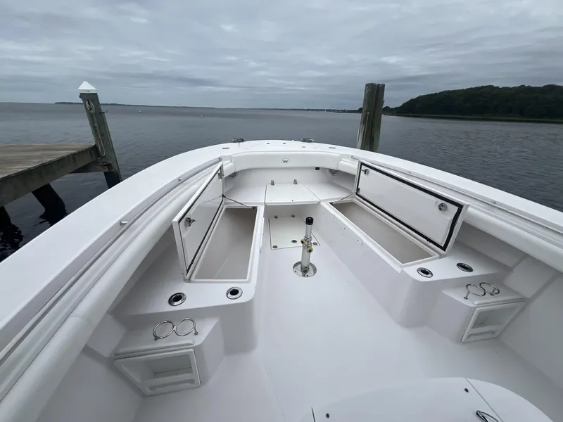 Slide: The Image of 2019 Southport 33 FE boat with open storage compartments, docked by a serene waterfront. - 7