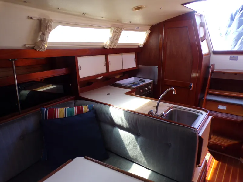 Slide: The Image of Interior of 1991 Catalina 34 sailboat with kitchen and seating area. - 12