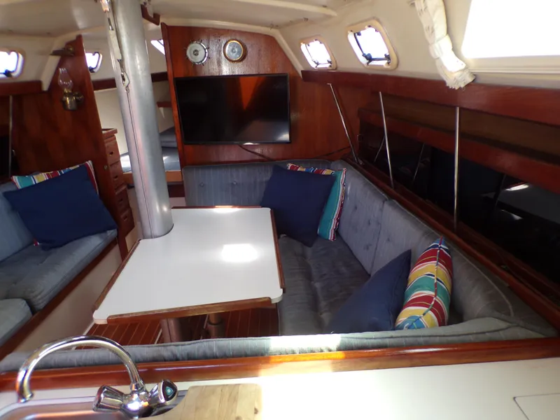 Slide: The Image of Interior of 1991 Catalina 34 sailboat with cozy seating and colorful cushions. - 15