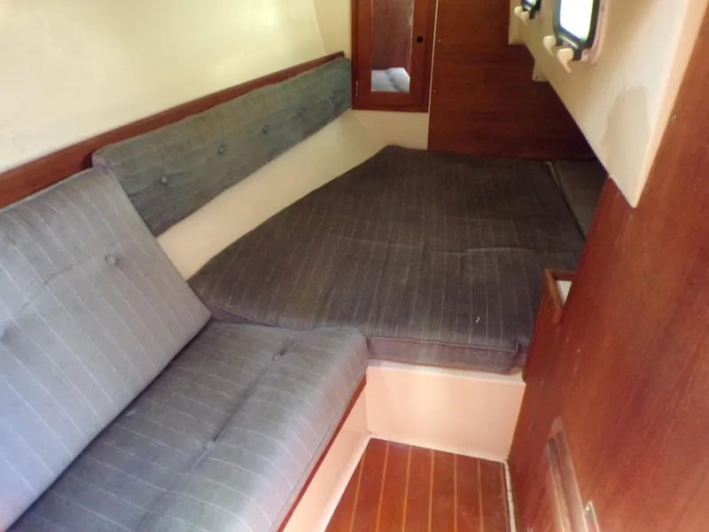 Slide: The Image of 1991 Catalina 34 interior cabin with cushioned seating and wooden accents. - 16