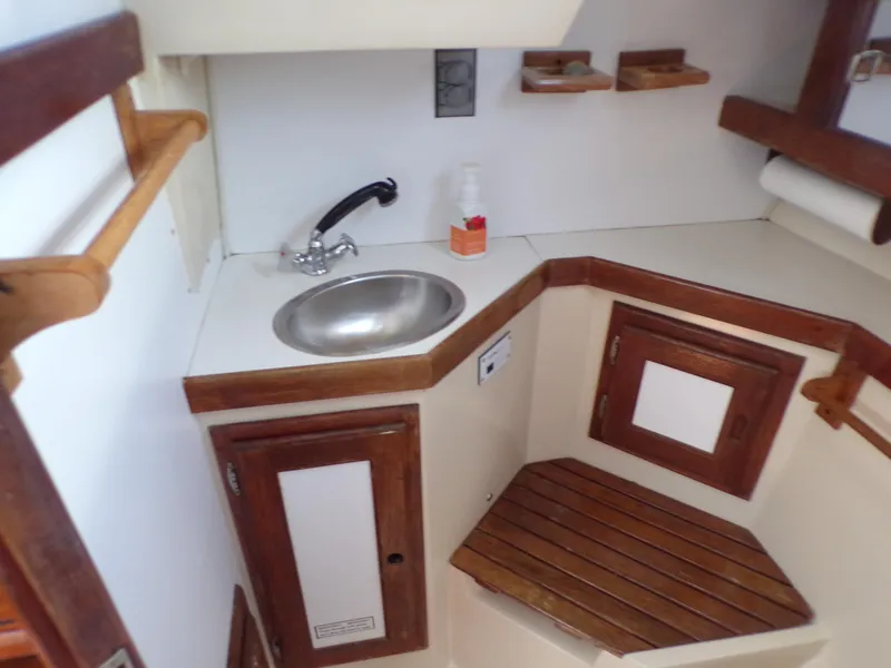 Slide: The Image of Interior of 1991 Catalina 34 sailboat with compact sink and wooden cabinetry. - 19