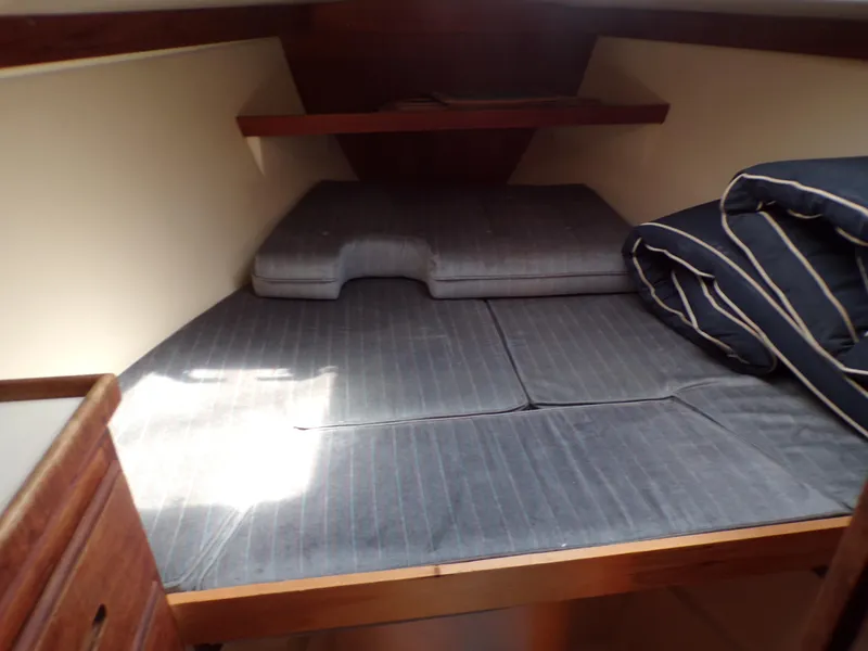 Slide: The Image of Cozy cabin interior of a 1991 Catalina 34 sailboat with cushioned sleeping area. - 21