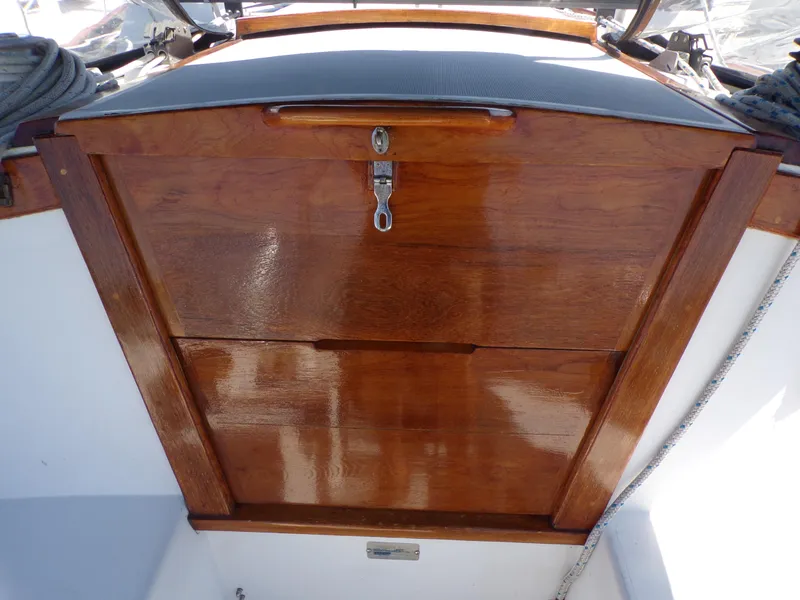 Slide: The Image of Wooden hatch of a 1991 Catalina 34 sailboat, featuring a polished finish and secure lock. - 27