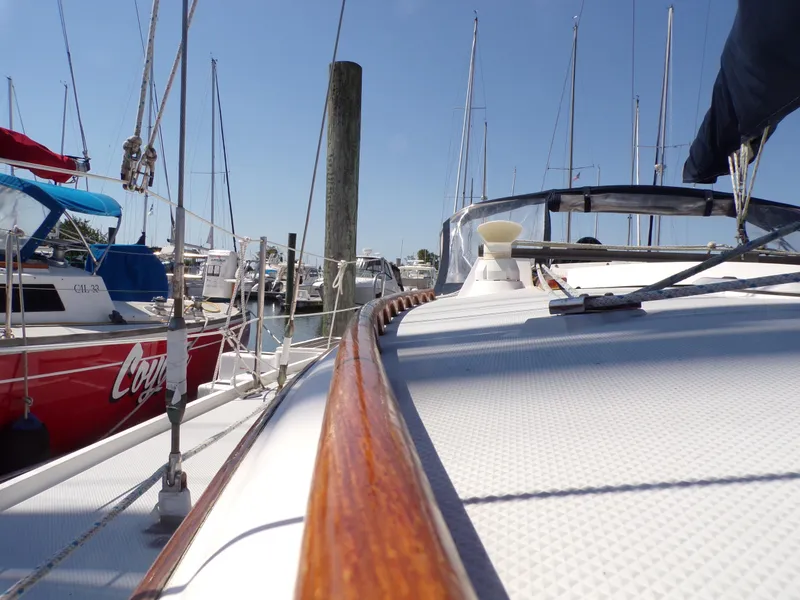 Slide: The Image of 1991 Catalina 34 sailboat docked in a marina, surrounded by other boats. - 31