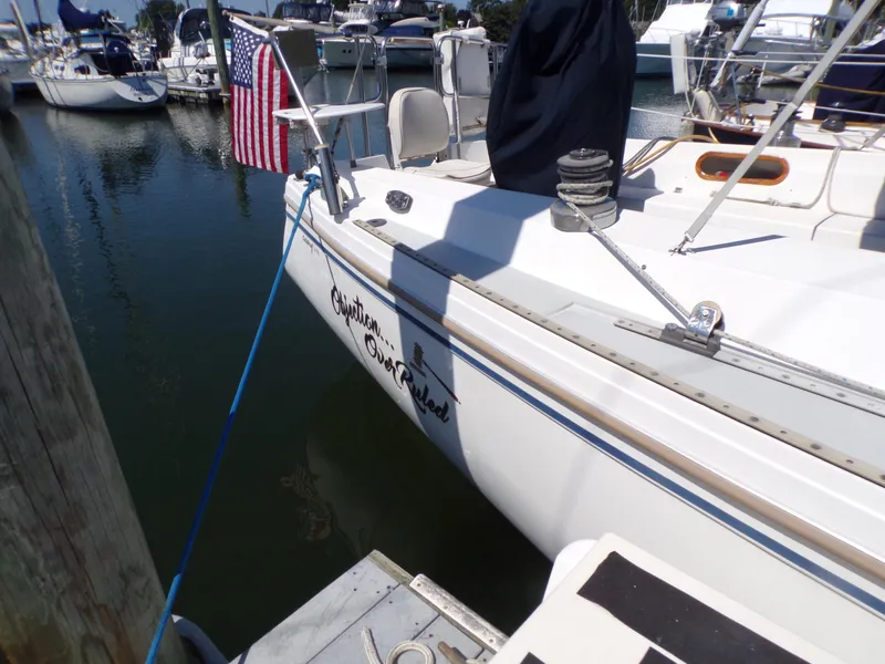 Slide: The Image of 1991 Catalina 34 sailboat docked, featuring American flag and marina background. - 33