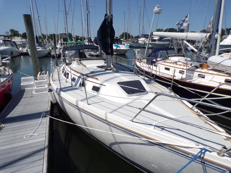 Slide: The Image of 1991 Catalina 34 sailboat docked at marina, surrounded by other boats. - 34