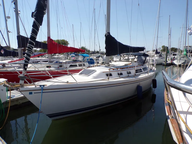 Slide: The Image of 1991 Catalina 34 sailboat docked in a marina, surrounded by other boats. - 35