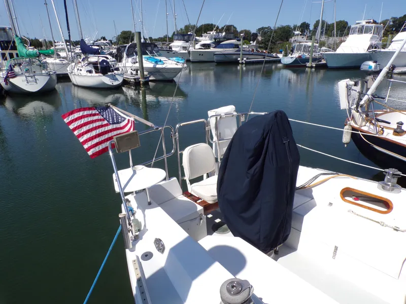 Slide: The Image of Sailboat Catalina 34, 1991 model, docked in a marina with an American flag. - 4