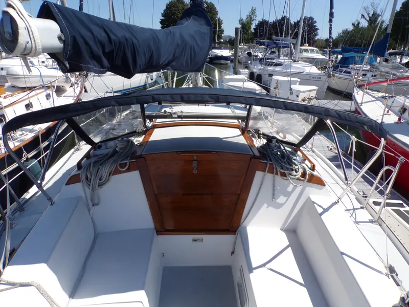 Slide: The Image of 1991 Catalina 34 sailboat cockpit with covered boom, docked among other boats. - 5