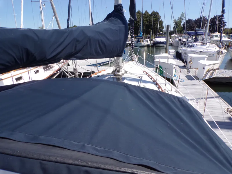 Slide: The Image of 1991 Catalina 34 sailboat docked at marina, covered sails, clear sky, calm water. - 9