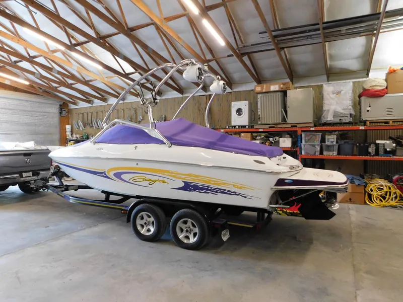 Slide: The Image of 2002 Baja 212 Islander boat with purple cover in a garage. - 12