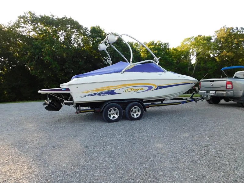 Slide: The Image of 2002 Baja 212 Islander boat on trailer, parked outdoors with trees in background. - 15