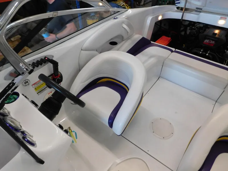 Slide: The Image of 2002 Baja 212 Islander boat interior with white and purple seating, steering wheel, and controls. - 3